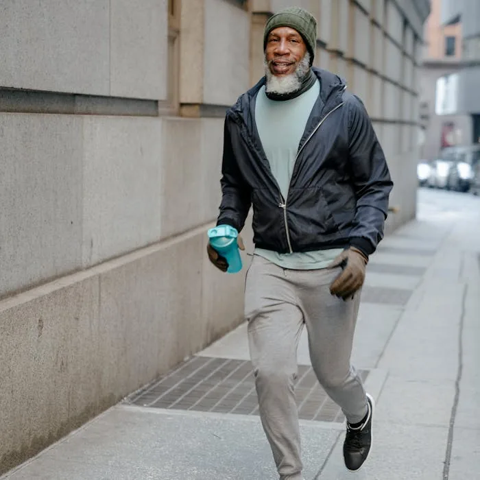 Senior man running outdoors with water bottle